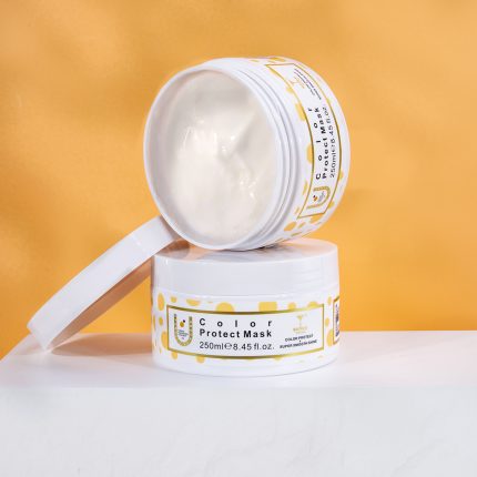 Two white cosmetic jars stacked on a white surface, labeled Color Protect Mask with yellow dot design against an orange background