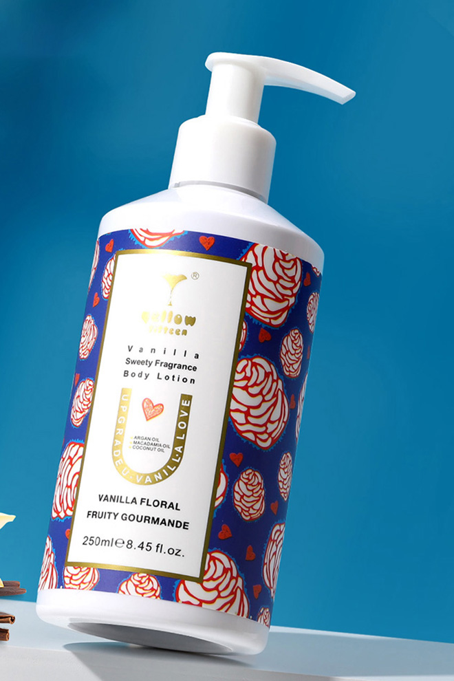 Pump bottle of Vanilla Floral Fruity Gourmande body lotion with a blue floral label on a blue background.