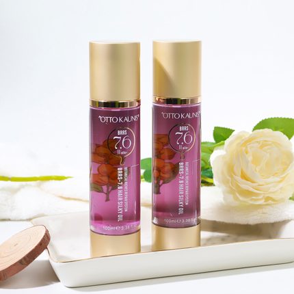 Two purple hair oil bottles with gold caps on a white tray, a white flower in the background.