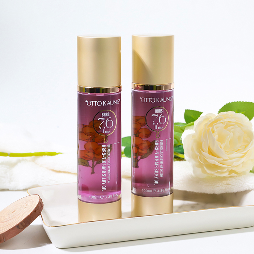 Two purple hair oil bottles with gold caps on a white tray, a white flower in the background.