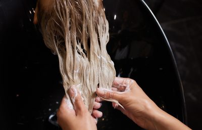 Stylist applying salon-exclusive hair treatment