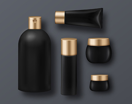 Set of black cosmetic containers with gold caps on a gray background: a tall bottle, a squeeze tube, a cylindrical bottle, and three jars in varying sizes.