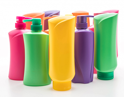 Colorful plastic shampoo bottles with pumps arranged on a white surface, ready for display or sale